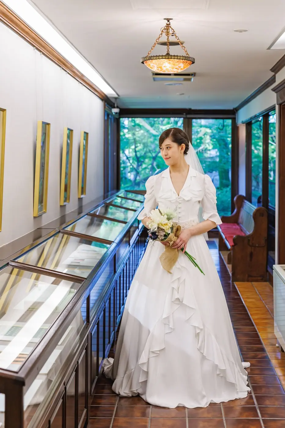 展示室でブーケを持つウェディングドレス姿の花嫁